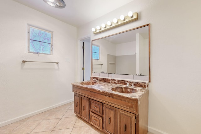 full bath featuring tile patterned floors, baseboards, and a sink