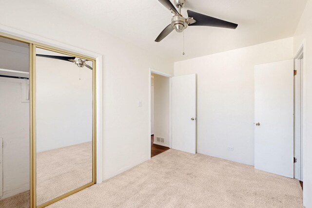 unfurnished bedroom with ceiling fan, carpet floors, visible vents, and a closet