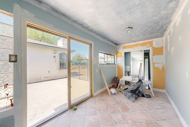 entryway with baseboards and light tile patterned floors
