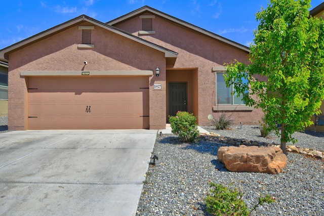 single story home featuring driveway, a garage, and stucco siding