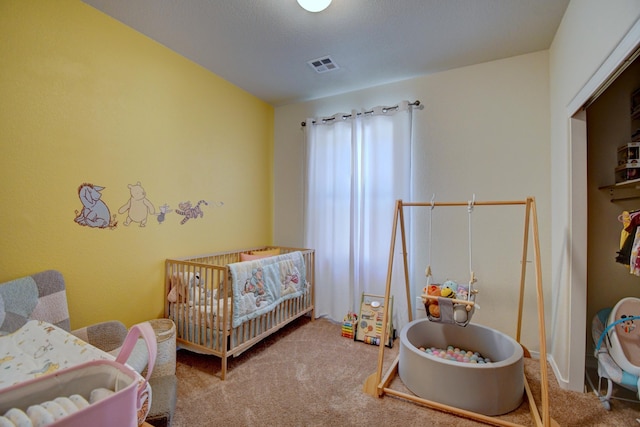 carpeted bedroom with visible vents and a nursery area