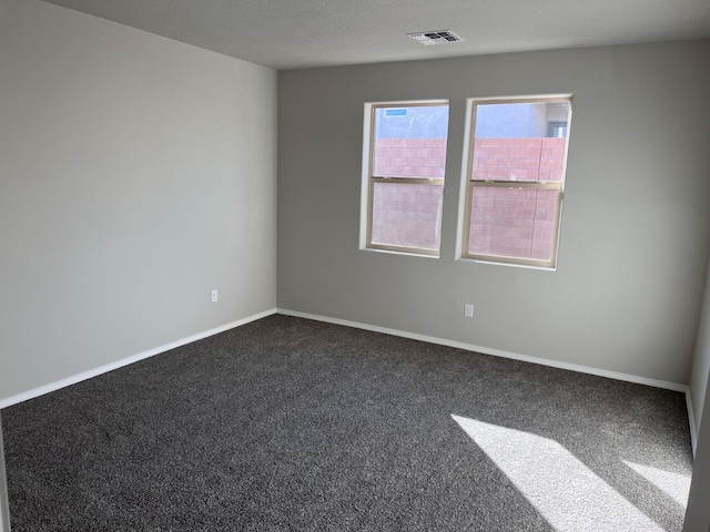 carpeted spare room featuring visible vents and baseboards
