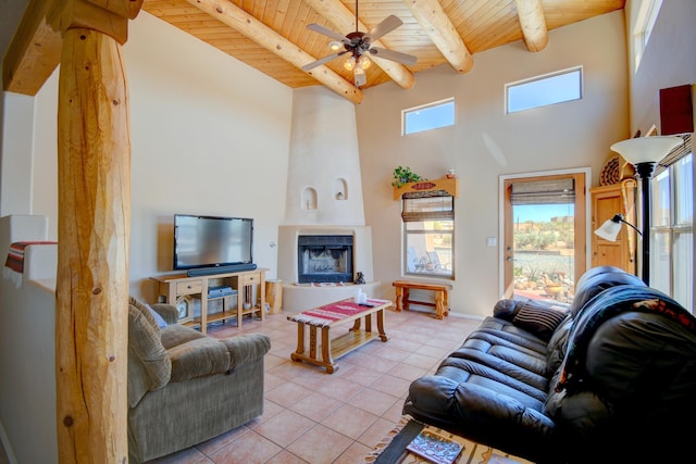 living area with a fireplace, light tile patterned floors, a towering ceiling, and wooden ceiling