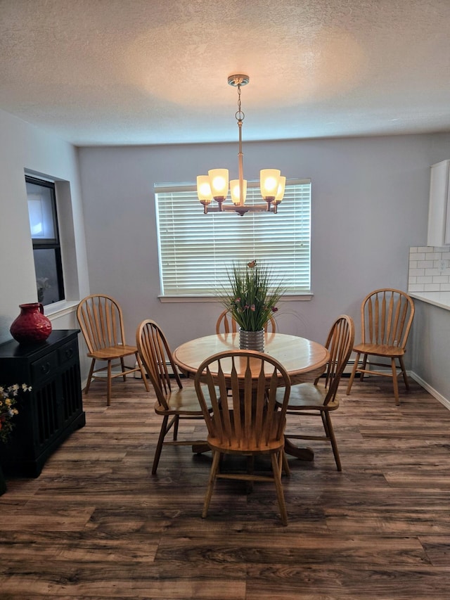 3404 Esplanade Pl SE, Rio Rancho, NM 87124 - dining space with a chandelier, dark wood-style flooring, a textured ceiling, and baseboards