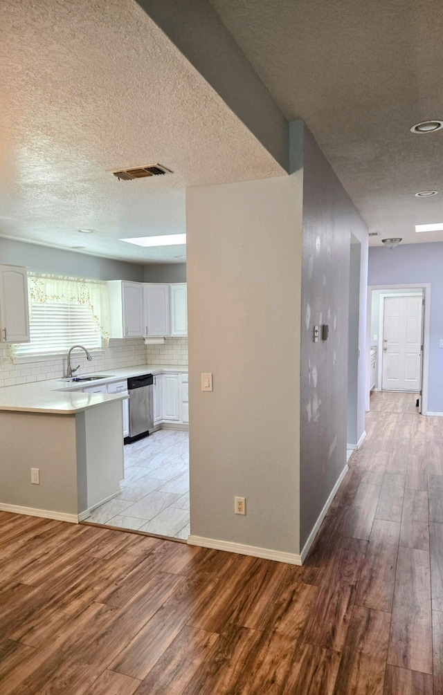 3404 Esplanade Pl SE, Rio Rancho, NM 87124 - kitchen featuring dishwasher, white cabinetry, light wood-style flooring, a sink, and light countertops