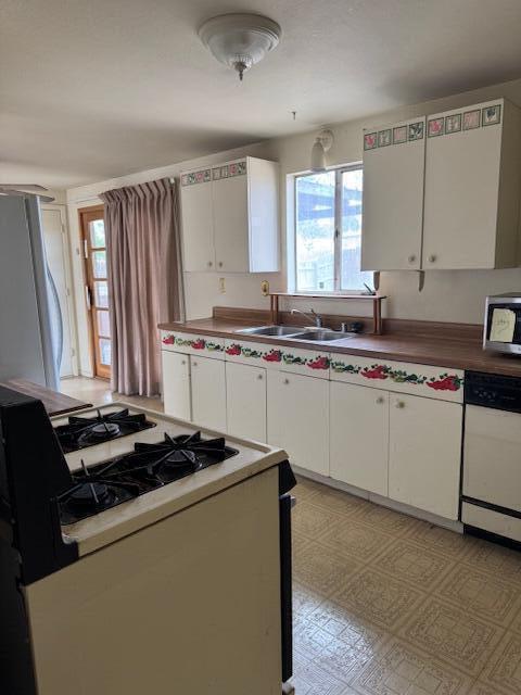 10509 San Jacinto Ave NE, Albuquerque, NM 87112 - kitchen featuring light floors, white cabinets, appliances with stainless steel finishes, and a sink
