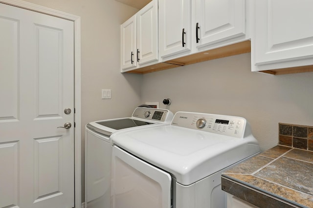 washroom with washing machine and clothes dryer and cabinet space