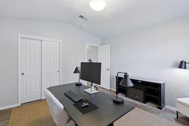 office featuring lofted ceiling, visible vents, and baseboards
