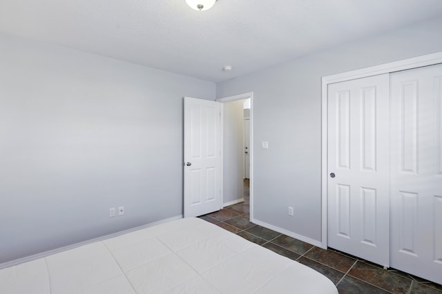 bedroom with baseboards and a closet