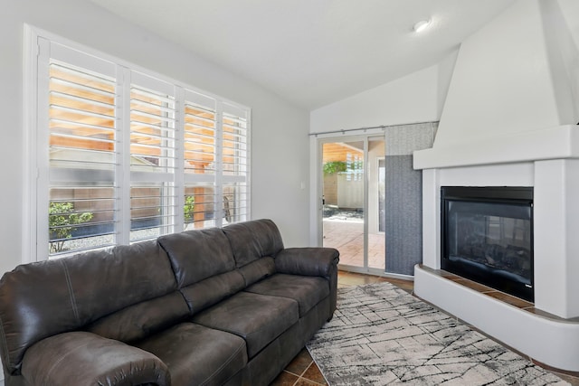 living area featuring lofted ceiling and a large fireplace