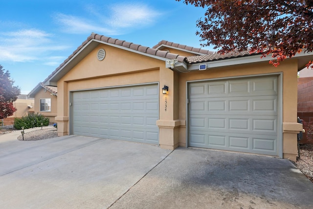 view of front of property with an attached garage, concrete driveway, stucco siding, and a tiled roof