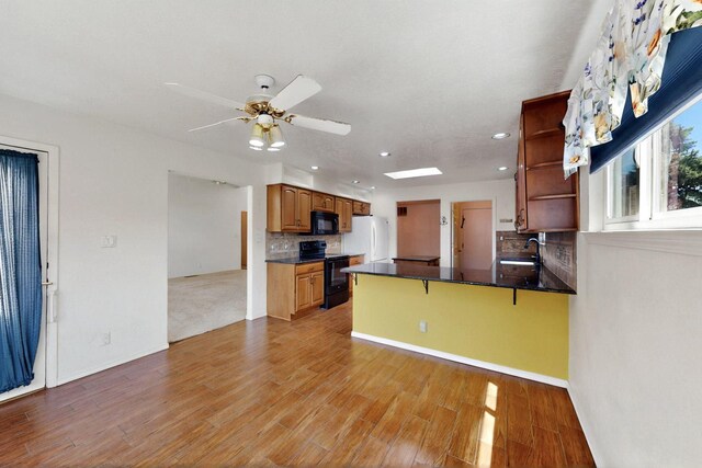 4532 Habershaw Rd NW, Albuquerque, NM 87120 - kitchen with black appliances, open shelves, a sink, dark countertops, and a peninsula