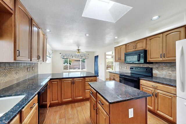 4532 Habershaw Rd NW, Albuquerque, NM 87120 - kitchen with black appliances, a skylight, recessed lighting, tasteful backsplash, and a peninsula