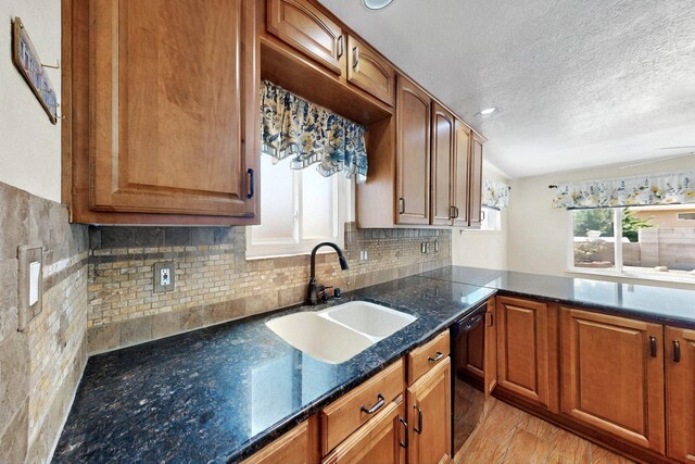 4532 Habershaw Rd NW, Albuquerque, NM 87120 - kitchen featuring a sink, black dishwasher, a textured ceiling, decorative backsplash, and brown cabinetry