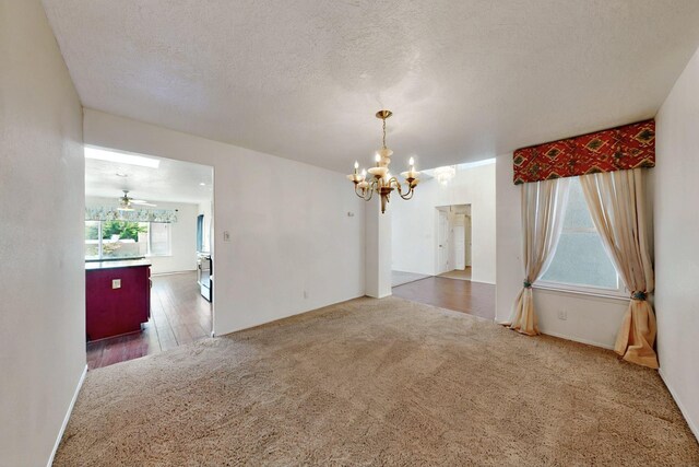 4532 Habershaw Rd NW, Albuquerque, NM 87120 - unfurnished dining area featuring a chandelier, carpet, and a textured ceiling