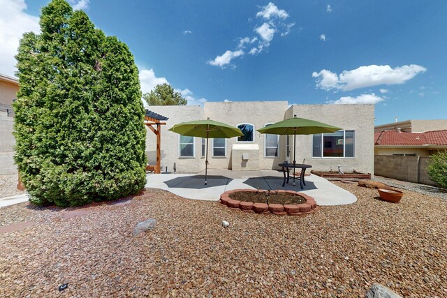 4532 Habershaw Rd NW, Albuquerque, NM 87120 - rear view of house with stucco siding, fence, and a patio