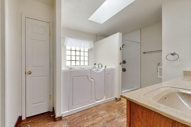 4532 Habershaw Rd NW, Albuquerque, NM 87120 - full bathroom with a skylight, tiled shower, and wood finished floors