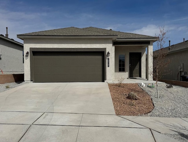prairie-style house featuring a shingled roof, stucco siding, concrete driveway, and an attached garage