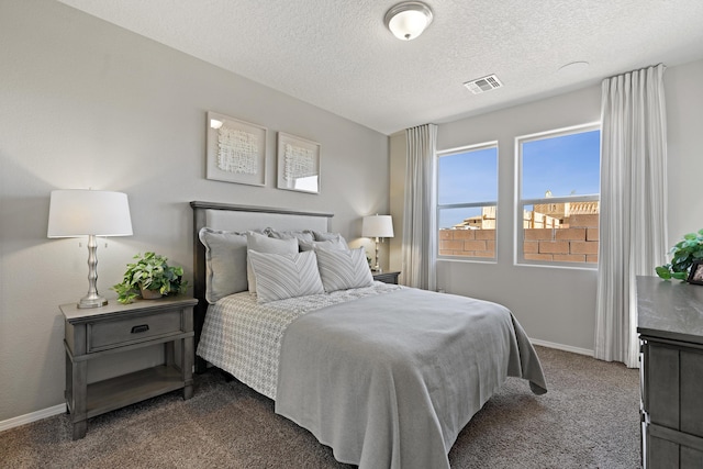 bedroom featuring baseboards, dark colored carpet, visible vents, and a textured ceiling
