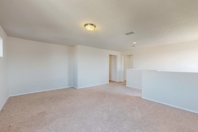 empty room featuring baseboards, visible vents, and light colored carpet