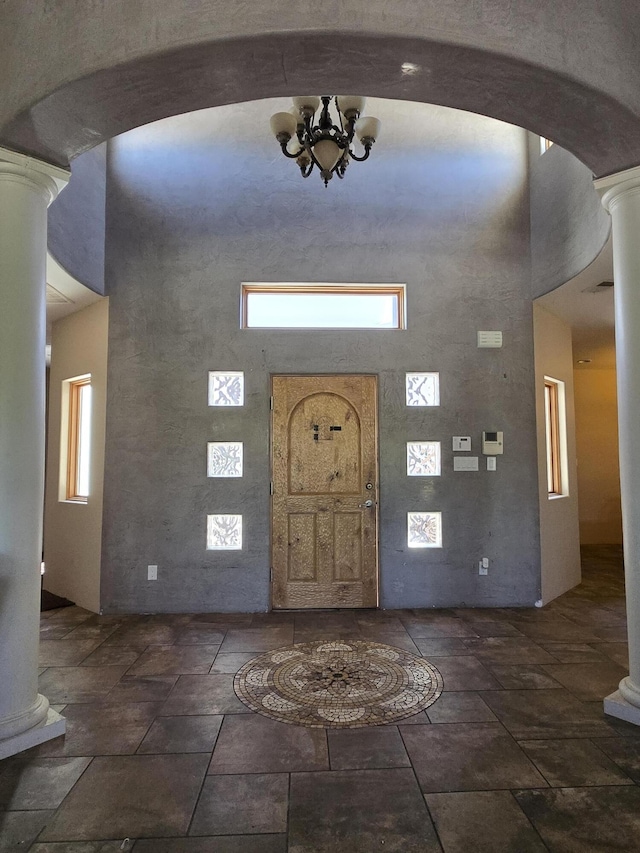 4505 Driftwood Ave NW, Albuquerque, NM 87114 - entryway with ornate columns, a towering ceiling, arched walkways, and stone tile flooring