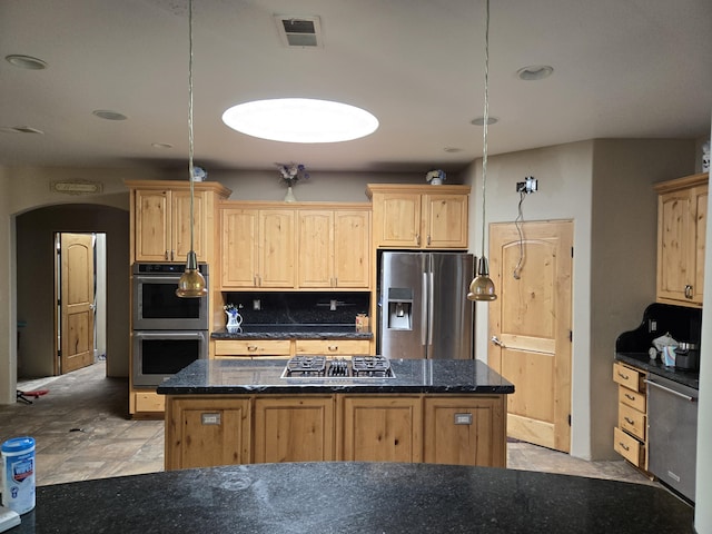 4505 Driftwood Ave NW, Albuquerque, NM 87114 - kitchen featuring stainless steel appliances, a kitchen island, light brown cabinets, arched walkways, and dark stone countertops