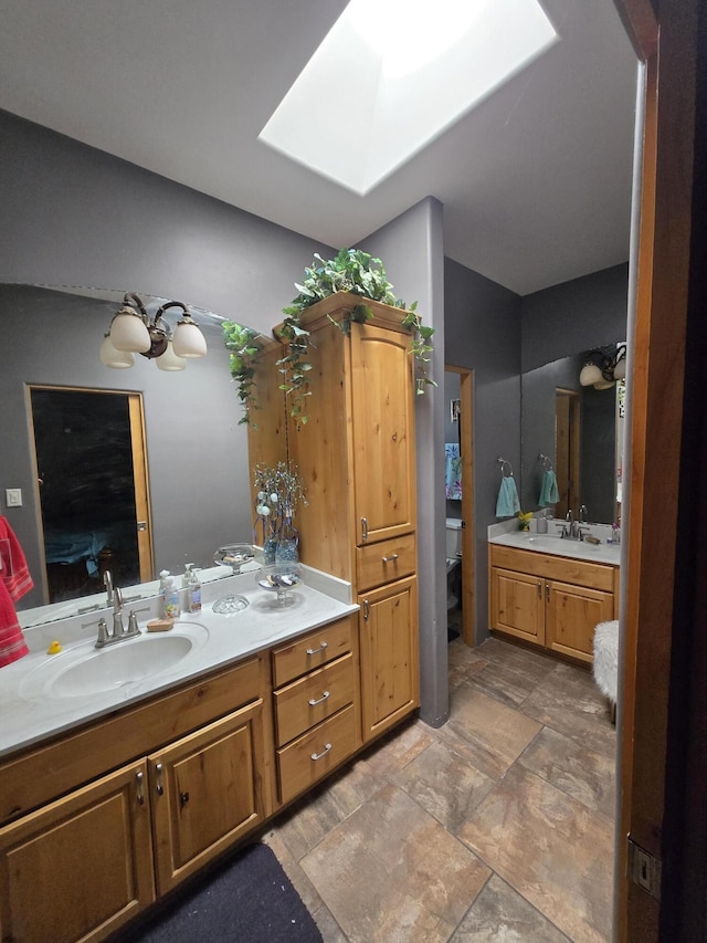 4505 Driftwood Ave NW, Albuquerque, NM 87114 - bathroom with a skylight, vanity, stone finish floors, and a chandelier