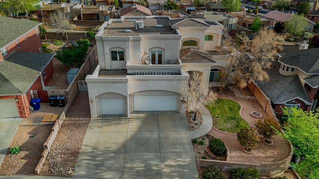 view of front of house with a residential view, driveway, stucco siding, and a balcony