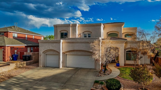 mediterranean / spanish house with concrete driveway, an attached garage, and stucco siding