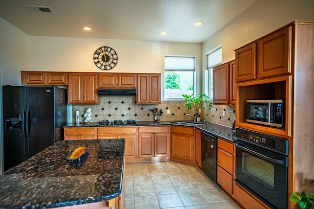 kitchen featuring light tile patterned floors, a sink, visible vents, under cabinet range hood, and black appliances