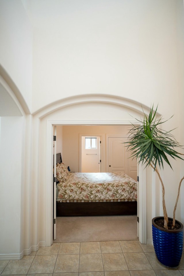 bedroom with light tile patterned floors and light colored carpet
