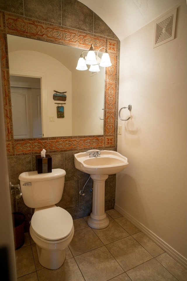 bathroom with toilet, tile patterned flooring, visible vents, and baseboards