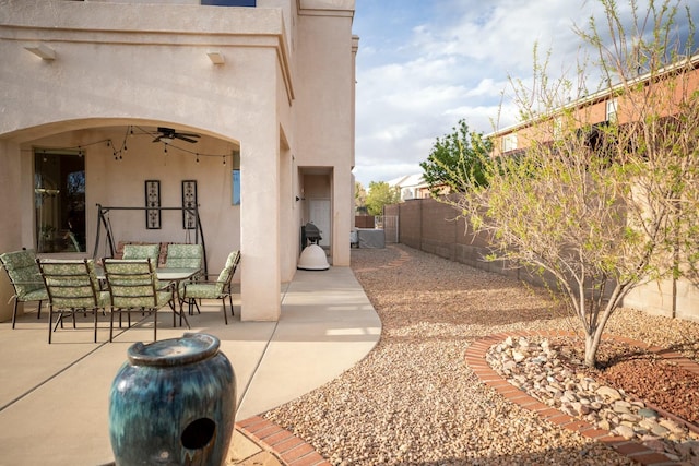 exterior space featuring outdoor dining space, a fenced backyard, and a ceiling fan