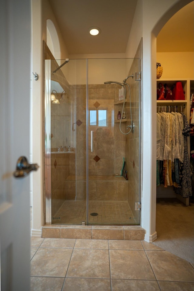 bathroom featuring tile patterned floors, recessed lighting, a stall shower, and a walk in closet