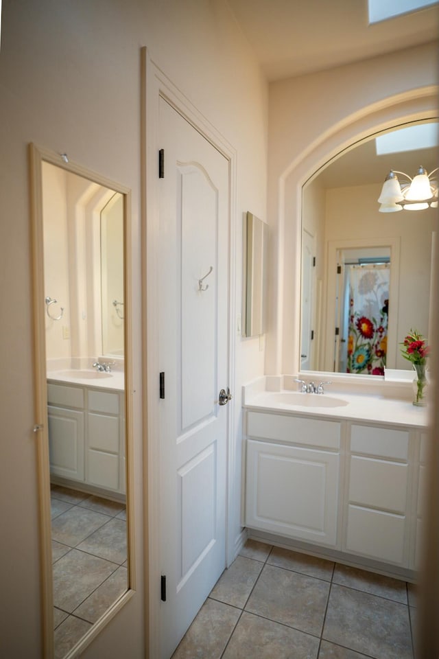 bathroom featuring a chandelier, tile patterned flooring, and vanity