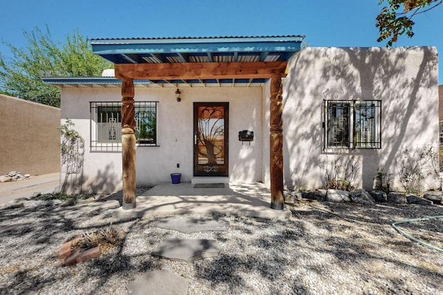 doorway to property featuring stucco siding