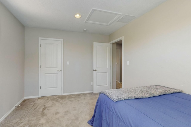 bedroom with attic access, light colored carpet, recessed lighting, and baseboards