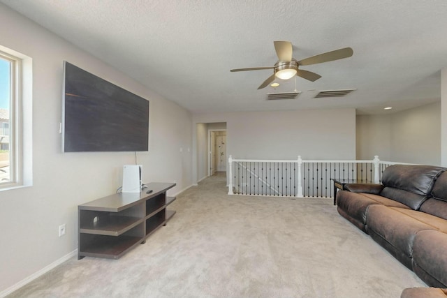 carpeted living area featuring visible vents, ceiling fan, and baseboards