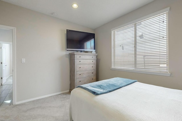 bedroom with baseboards, recessed lighting, multiple windows, and light colored carpet