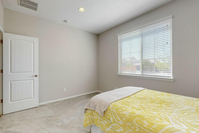 bedroom featuring baseboards, visible vents, a textured ceiling, and carpet flooring