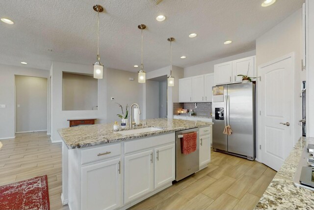9112 Lansdowne Pl NE, Albuquerque, NM 87113 - kitchen with appliances with stainless steel finishes, a sink, white cabinetry, an island with sink, and recessed lighting