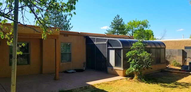 rear view of property with stucco siding and a patio area