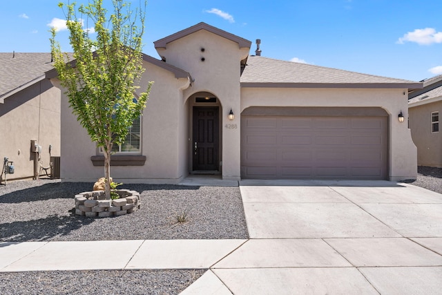 view of front of house with driveway, roof with shingles, an attached garage, stucco siding, and central AC