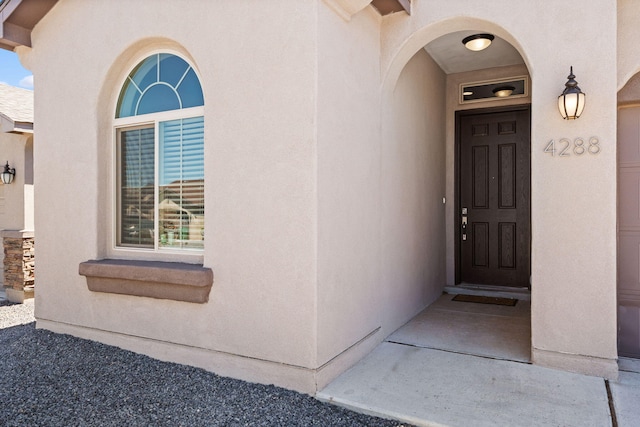 view of exterior entry featuring stucco siding