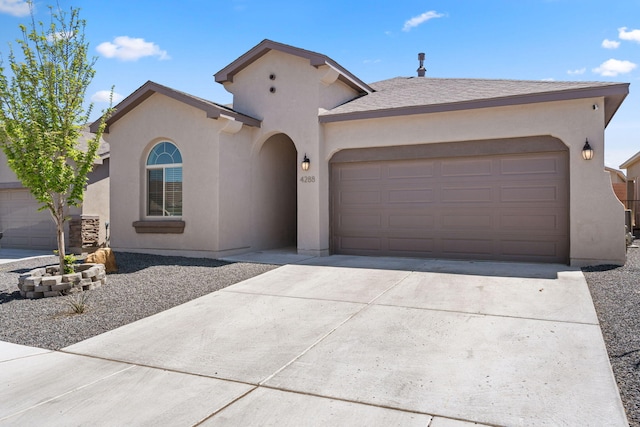 mediterranean / spanish-style home with stucco siding, concrete driveway, and an attached garage
