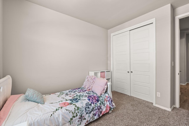 carpeted bedroom featuring baseboards, lofted ceiling, and a closet