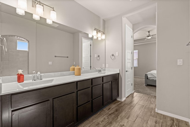 full bath featuring a ceiling fan, a sink, wood finished floors, and baseboards