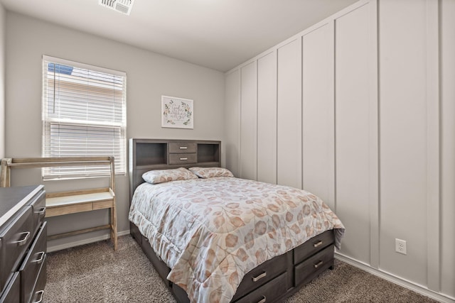 bedroom with visible vents, dark colored carpet, and baseboards