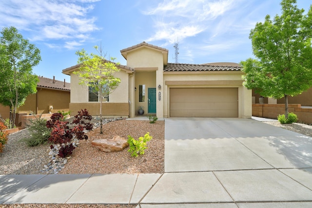 6952 Napoleon Rd NE, Rio Rancho, NM 87144 - mediterranean / spanish house featuring a garage, stucco siding, a tile roof, and concrete driveway