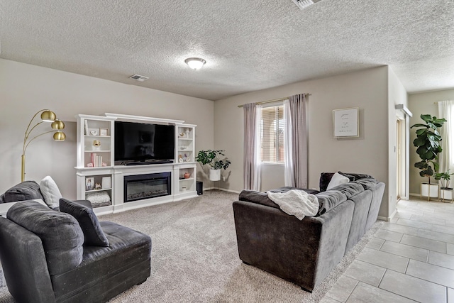 6952 Napoleon Rd NE, Rio Rancho, NM 87144 - living room featuring a glass covered fireplace, baseboards, a textured ceiling, and visible vents